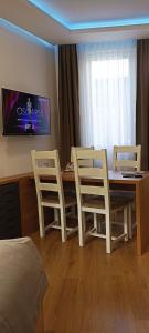 a room with a table and chairs and a tv at Apartments "Tuffo" in Sarajevo
