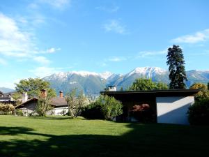 a house in a field with mountains in the background at Muralto - Locarno: Miramonti Apt.5 in Muralto