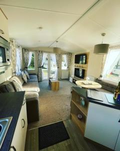 a kitchen and living room with a couch and a table at Twilight Escape in Swarland