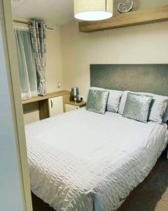 a bedroom with a white bed with blue pillows at Twilight Escape in Swarland