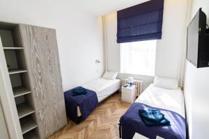 Habitación pequeña con 2 camas y ventana en HOT SPOT Vilnius Apartments! en Vilna