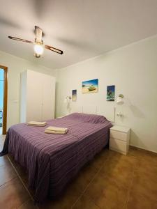 una camera con letto viola e ventilatore a soffitto di Apartment Playa las Vistas a Playa de las Americas