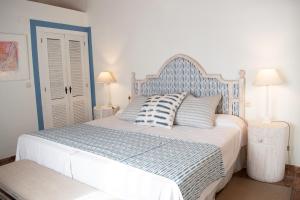 a bedroom with a blue and white bed with two lamps at Hotel Cortijo del Arte - Caminito del Rey in Pizarra