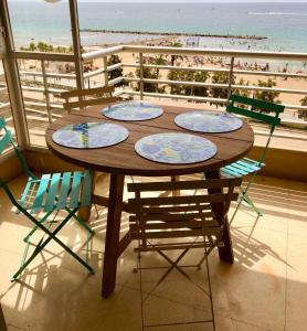 a wooden table with four chairs and a view of the beach at Stunning Sea View in Alicante