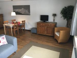 a living room with a couch a table and a tv at Appartement Liesl, ruim 4 pers. appartement met eigen tuin! in Ehrwald