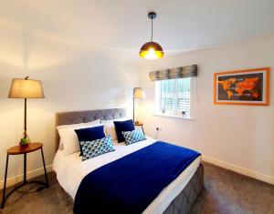 a bedroom with a bed with blue sheets and a window at Luxury Coastal Retreat in Loftus