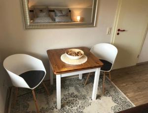 a table with two chairs and a bowl on it at Landhaus Sonneninsel - Appartement in Minheim
