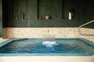 a large pool of water in a bathroom at Domaine de Bellevue, The Originals Relais (Relais du Silence) in Neufmoutiers-en-Brie