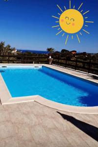 a swimming pool with a sun sign on the fence at Au bien être in Bastia