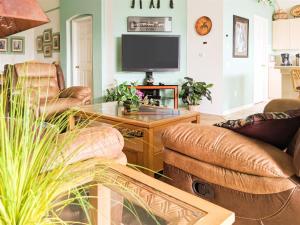 a living room with leather furniture and a flat screen tv at 4 Bed 2269 in Kissimmee