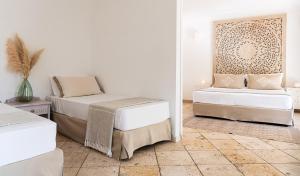 a bedroom with two beds and a tiled floor at Falkensteiner Resort Capo Boi in Villasimius