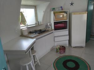 uma pequena cozinha com um frigorífico branco e um balcão em Cabanas de Tucuns em Búzios