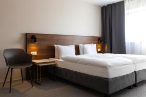 a hotel room with a bed and a chair at Hotel Santin in Bełchatów