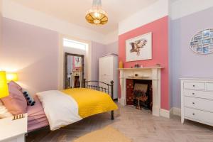 um quarto com uma cama e uma lareira em Chic Edwardian Home With Garden em Kent