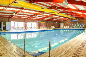 a large indoor swimming pool with blue water at Beaches45 in Hythe