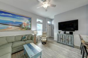 sala de estar con sofá y TV de pantalla plana en Latitude Adjustment, en Padre Island