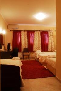 a hotel room with two beds and a red rug at Asteras Hotel in Naousa Imathias