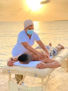 a woman in a mask sitting on the beach at Quinta del Mar Tintipán in Isla Mucura