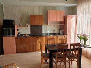 una cocina con armarios de madera, mesa y sillas en Viste Funäsdalen en Funäsdalen
