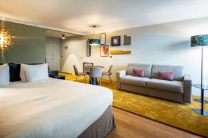 una camera d'albergo con letto e divano di Holiday Inn Hotel Brussels Airport, an IHG Hotel a Diegem