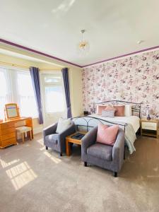 a bedroom with a bed and a couch and a chair at Coastal Waters (Hotel Barton) in Torquay