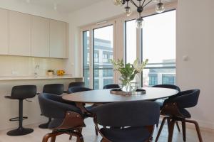 a kitchen and dining room with a table and chairs at Mennica Residence Luxury Suite by Renters Prestige in Warsaw