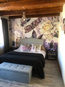 a bedroom with a bed with a floral wall at Chambres d'Hôtes LES VERGERS DE LOUISE in Thiolières