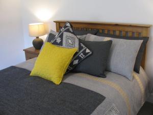 Una cama con una almohada amarilla encima. en Wintergreen en Pitlochry