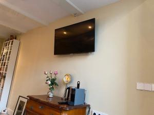 una TV a schermo piatto sulla parete di una camera di Prinsengracht Museum Bed and Breakfast ad Amsterdam