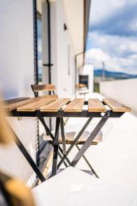 una mesa de madera en un balcón con sillas en Casas da Padaria en Celorico de Basto