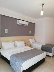 a hotel room with two beds and a heater at Viras Hotel in Ortakent