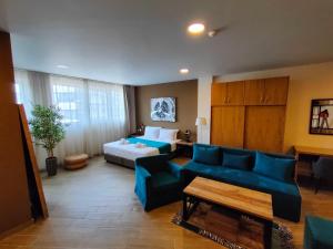 pokój hotelowy z łóżkiem i niebieską kanapą w obiekcie La Place Suites - La Place De La Gare w Salonikach