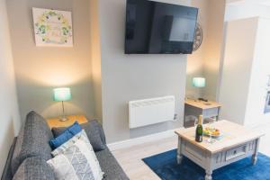 een woonkamer met een bank en een tv bij Charming 6 Bedroom House ALL with en-suite - Large Garden in Tamworth