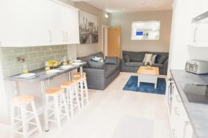 a kitchen and living room with a bar and a couch at Charming 6 Bedroom House ALL with en-suite - Large Garden in Tamworth