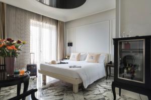 una camera con un letto bianco e una grande finestra di Hotel Metropole Taormina a Taormina
