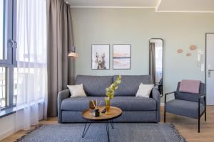 uma sala de estar com um sofá azul e uma cadeira em limehome Aalen Reichsstädter Str. em Aalen