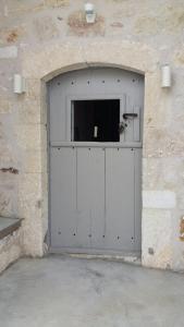 una gran puerta metálica de garaje en una pared de piedra en White Sea Houses Village, en Kimolos