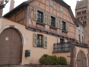 uma casa antiga com janelas e portas e um edifício em Gîte Madeleine et Clémentine em Gueberschwihr