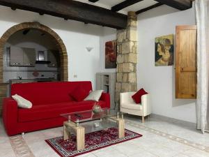 sala de estar con sofá rojo y mesa en La Fanciulla Velca, en Tarquinia