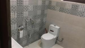 a bathroom with a white toilet and a shower at Shaheen rest house Islamabad in Islamabad