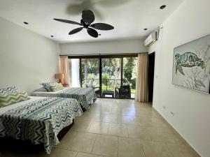 salon z łóżkiem i wentylatorem sufitowym w obiekcie Stunning Oceanfront 4-Bdrm Villa w/ Infinity Pool w mieście San Lorenzo