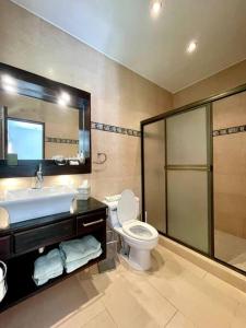 a bathroom with a toilet and a sink and a shower at Stunning Oceanfront 4-Bdrm Villa w/ Infinity Pool in San Lorenzo +15 photos