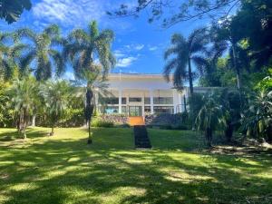 a building with palm trees in front of it at Stunning Oceanfront 4-Bdrm Villa w/ Infinity Pool in San Lorenzo