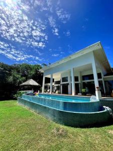 a house with a swimming pool in the grass at Stunning Oceanfront 4-Bdrm Villa w/ Infinity Pool in San Lorenzo