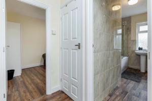 baño con puerta blanca y lavamanos en 2-Bed House - Sleeps 7 & Free Parking, en Barking 21 fotos más