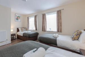 Un dormitorio con dos camas y una ventana en 2-Bed House - Sleeps 7 & Free Parking, en Barking