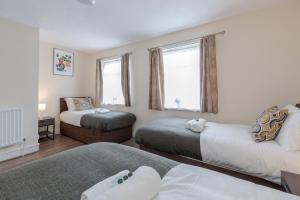 a bedroom with two beds and a window at Beautiful 2-Bed House in quiet cul-de-sac in Barking