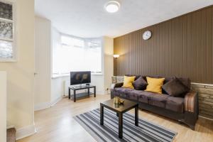 a living room with a couch and a tv at Beautiful 2-Bed House in quiet cul-de-sac in Barking