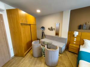 a room with a bed and a table and a couch at La Place de la Gare Suites - New Subway Station in Thessaloniki +44 photos