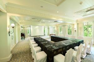 a conference room with a long table and white chairs at Heritage Le Telfair Golf & Wellness Resort in Bel Ombre +80 photos